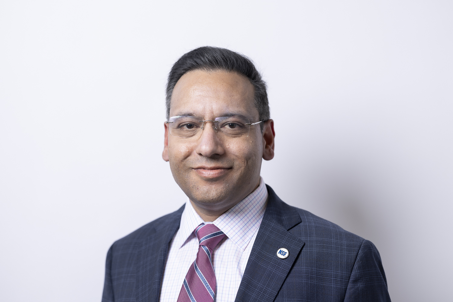 Dr. Kush Dhody, professional portrait in navy suit